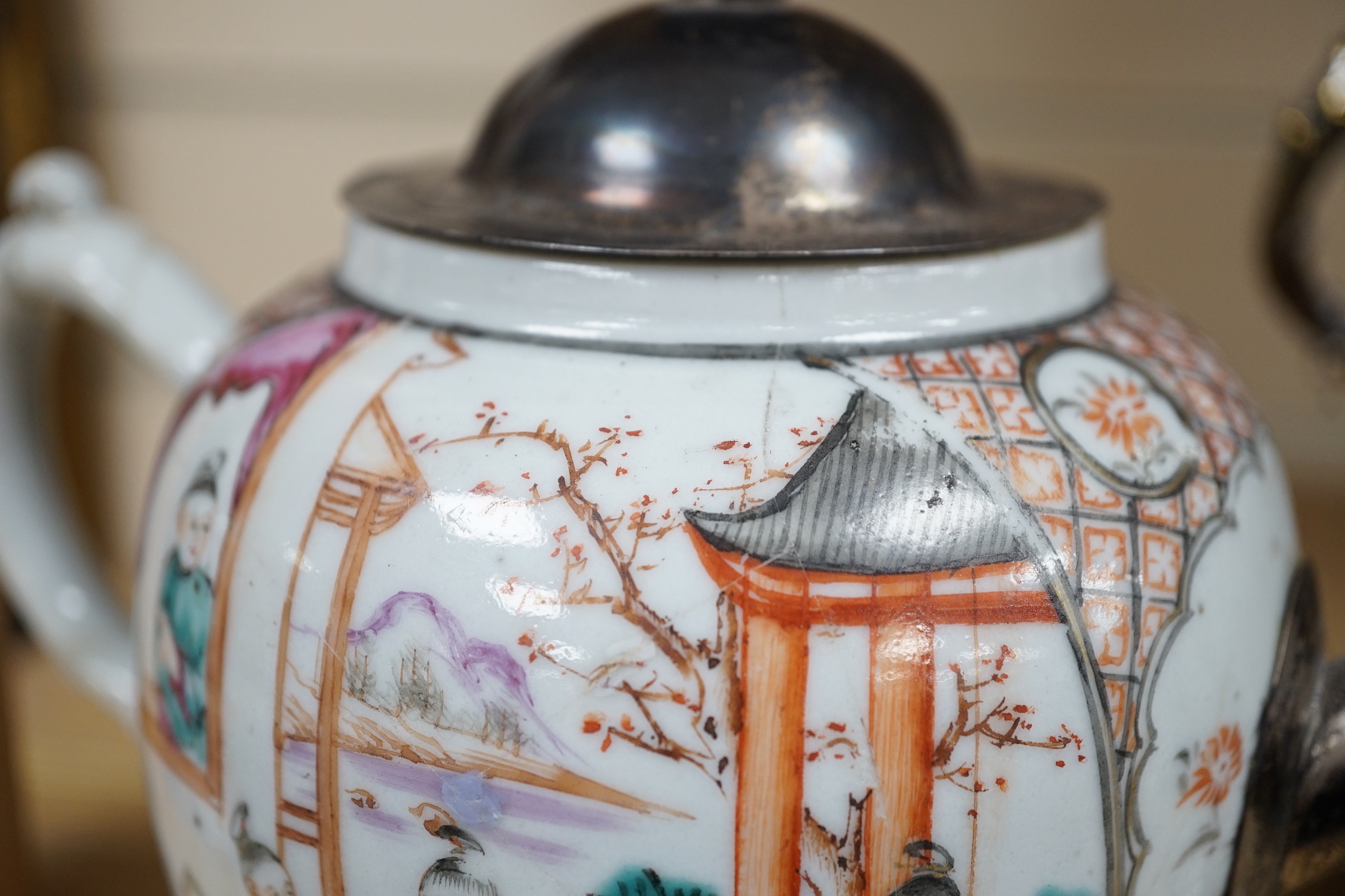 An 18th century Chinese export famille rose teapot with later silver spout and cover, on hardwood stand